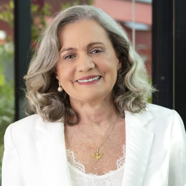 Retrato da Dra. Míria de Amorim, sorrindo, de blazer branco