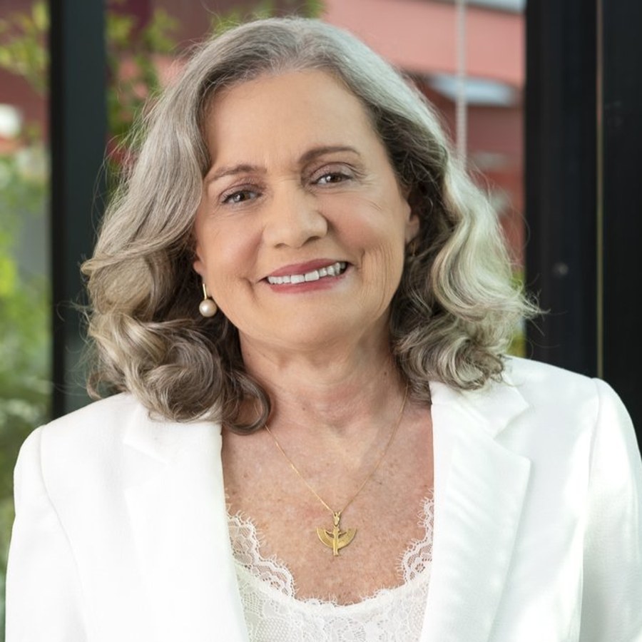Retrato da Dra. Míria de Amorim, sorrindo, de blazer branco