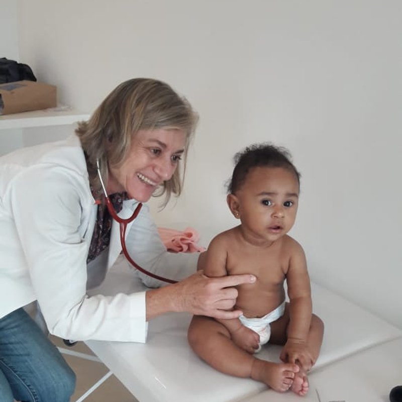 Médica examina bebê com estetoscópio durante atendimento gratuito